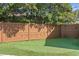 Backyard putting green with artificial turf and a wood privacy fence at 4935 W Bay Way Pl, Tampa, FL 33629