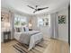 Well-lit bedroom featuring two windows, ceiling fan, and light wood floors at 506 71St Ave # 7, St Pete Beach, FL 33706