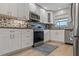 Bright kitchen featuring granite countertops, mosaic backsplash, stainless steel appliances, and ample cabinet space at 506 71St Ave # 7, St Pete Beach, FL 33706