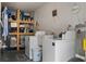 Well-equipped laundry room with washer, dryer, utility sink, water heater, and ample shelving at 506 71St Ave # 7, St Pete Beach, FL 33706