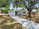 Inviting home featuring a long driveway, a modern green front door, and decorative cinder block wall detail at 5121 Flamingo N Dr, St Petersburg, FL 33714