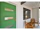 Close-up of front porch with a modern green door, wooden chairs, and large window at 5121 Flamingo N Dr, St Petersburg, FL 33714