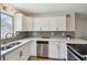 Bright kitchen featuring stainless steel appliances, white cabinets, and a gray backsplash at 5121 Flamingo N Dr, St Petersburg, FL 33714