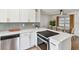 Well-lit kitchen with stainless steel appliances, modern white cabinets, and a view into the dining area at 5121 Flamingo N Dr, St Petersburg, FL 33714