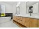 Bright bathroom with a soaking tub, marble countertops, modern fixtures, and wood-look vanity at 5406 N Pershing Pl, Tampa, FL 33603