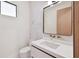 Modern half bathroom with marble accent wall, sleek vanity, and gold fixtures at 5406 N Pershing Pl, Tampa, FL 33603