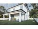 Backyard exterior with a covered porch and a lush green lawn, perfect for outdoor living at 5406 N Pershing Pl, Tampa, FL 33603