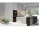Modern kitchen with sleek cabinets, stainless steel appliances, and a center island with a sink at 5406 N Pershing Pl, Tampa, FL 33603