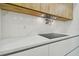 Modern kitchen with a smooth cooktop, wooden cabinets, marble countertops, and a stainless steel faucet at 5406 N Pershing Pl, Tampa, FL 33603