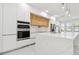 Modern kitchen featuring white cabinets, stainless steel appliances, and a large marble island with sink at 5406 N Pershing Pl, Tampa, FL 33603