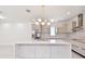 Open kitchen featuring white cabinetry, a large island with bar seating, and stainless steel appliances at 5406 N Pershing Pl, Tampa, FL 33603