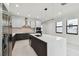 Open kitchen featuring stainless steel appliances, dark wood cabinets, and a large white center island at 5406 N Pershing Pl, Tampa, FL 33603