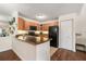 Open kitchen featuring tile flooring, black appliances, and wood-look cabinets at 5636 Baywater Dr # 5636, Tampa, FL 33615