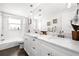 Bright bathroom with double vanity, white cabinets, subway tile, and bathtub at 6129 Leeland S St, St Petersburg, FL 33715