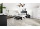 Well-lit bedroom with a ceiling fan, hardwood floors, and a bench near a window at 6129 Leeland S St, St Petersburg, FL 33715