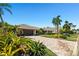 Beautiful home showcasing a well-manicured lawn, lush landscaping, and a brick-paved driveway leading to a two-car garage at 6129 Leeland S St, St Petersburg, FL 33715