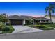 Charming home with a tile roof, paver driveway and meticulous landscaping against a backdrop of a colorful sunset sky at 6129 Leeland S St, St Petersburg, FL 33715