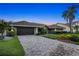 Charming home with a tile roof, paver driveway and meticulous landscaping against a backdrop of a colorful sunset sky at 6129 Leeland S St, St Petersburg, FL 33715