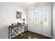 Inviting foyer featuring an ornate entry door, designer console table, and wood-look tile flooring at 6129 Leeland S St, St Petersburg, FL 33715