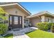 Inviting entryway with a decorative glass front door, neatly trimmed hedges, and a cozy seating area at 6129 Leeland S St, St Petersburg, FL 33715