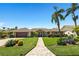 Charming home with a well-maintained lawn, mature palm trees, and a brick pathway leading to the front door at 6129 Leeland S St, St Petersburg, FL 33715