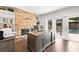 Bright home office with a brick fireplace, built-in shelving, and access to the outdoor pool area at 6129 Leeland S St, St Petersburg, FL 33715