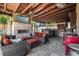 Cozy outdoor living area with a fireplace, plush seating, and a fully equipped kitchen under a stylish covered patio at 6129 Leeland S St, St Petersburg, FL 33715