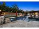 Backyard with an outdoor pool and fire feature, tiki torches, an outdoor lounge and mature landscaping at 6129 Leeland S St, St Petersburg, FL 33715