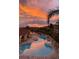 Sunset view of a community pool surrounded by lush palm trees at 6303 Vista Verde E Dr, Gulfport, FL 33707