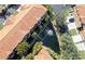 An aerial view shows a pond behind the orange-roofed townhomes with lush tropical landscaping at 6303 Vista Verde E Dr, Gulfport, FL 33707