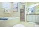 Spacious bathroom featuring a built-in tub, vanity, and open doorway at 6303 Vista Verde E Dr, Gulfport, FL 33707