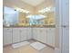 Well-lit bathroom featuring double sinks, granite countertops, and ample mirror space at 6303 Vista Verde E Dr, Gulfport, FL 33707