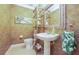 Charming half bathroom featuring a pedestal sink, decorative mirror, and tropical-themed decor at 6303 Vista Verde E Dr, Gulfport, FL 33707
