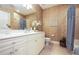 Well-lit bathroom with dual sink vanity, bathtub-shower combo and elegant seashell wall art accents at 6303 Vista Verde E Dr, Gulfport, FL 33707