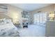 Comfortable bedroom featuring neutral decor, a decorative headboard, and shuttered doors to a balcony at 6303 Vista Verde E Dr, Gulfport, FL 33707