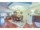 Open dining room with hardwood floors, a large rug, decorative lighting, and adjacent sitting area at 6303 Vista Verde E Dr, Gulfport, FL 33707