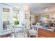 Bright dining area with glass table, wicker chairs, and doors to the outdoor living space at 6303 Vista Verde E Dr, Gulfport, FL 33707