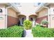 Charming townhome entrance with lush landscaping and decorative flower arrangements at 6303 Vista Verde E Dr, Gulfport, FL 33707