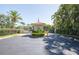 View of the gated entrance featuring an American flag and tropical landscaping at 6303 Vista Verde E Dr, Gulfport, FL 33707