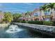 Scenic view of townhomes with balconies overlooking a tranquil pond and fountain at 6303 Vista Verde E Dr, Gulfport, FL 33707