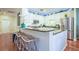 Open kitchen featuring a breakfast bar with wicker stools, granite countertops, and stainless steel appliances at 6303 Vista Verde E Dr, Gulfport, FL 33707