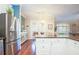 Bright kitchen with stainless steel refrigerator, granite countertops, and hardwood floors leading to dining area at 6303 Vista Verde E Dr, Gulfport, FL 33707