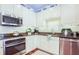 Well-equipped kitchen with stainless steel appliances, granite countertops, and white cabinets at 6303 Vista Verde E Dr, Gulfport, FL 33707