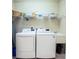 Bright laundry room features a sink, shelving, washer, and dryer at 6303 Vista Verde E Dr, Gulfport, FL 33707