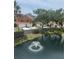 Scenic view of a community pond with a fountain surrounded by townhomes and lush landscaping at 6303 Vista Verde E Dr, Gulfport, FL 33707
