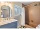 Cozy bathroom featuring a marble vanity and a tiled shower area with a curtain at 6702 Towhe Dr, Seffner, FL 33584