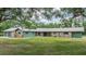 Charming single-story house with stone accents, green siding, and a meticulously maintained lawn at 6702 Towhe Dr, Seffner, FL 33584