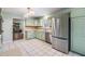 Light green kitchen with stainless steel appliances and adjacent view to the living room and fireplace at 6702 Towhe Dr, Seffner, FL 33584