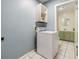 Bright laundry area with a white washer and dryer, and a glimpse of the nearby powder room at 6702 Towhe Dr, Seffner, FL 33584