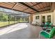 Inviting screened-in patio area with tile flooring and views of the landscaped backyard, ideal for relaxation at 6702 Towhe Dr, Seffner, FL 33584